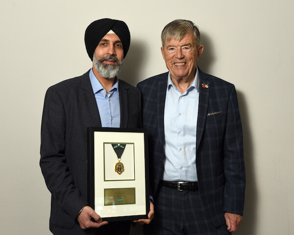 jaswindra singh nadra holding certificate standing next to doug perkins